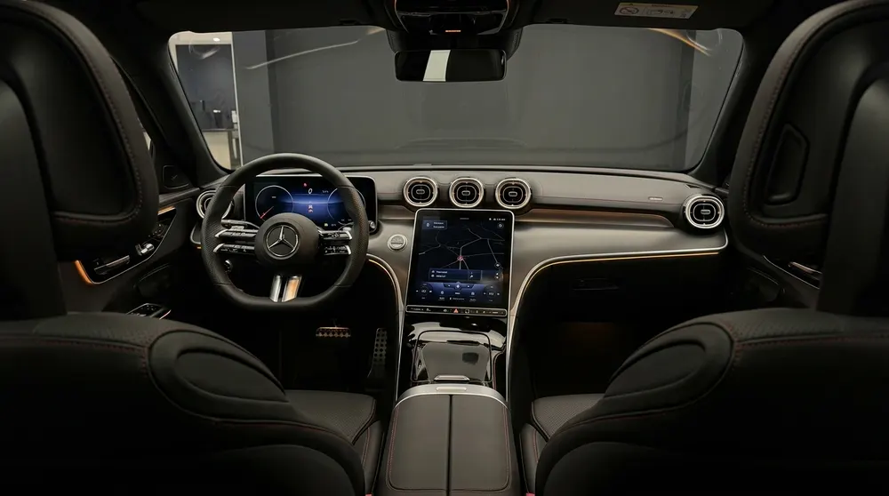 Mercedes-Innenraum bei Nacht mit bernsteinfarbenem Ambientelicht und Breitbildschirm