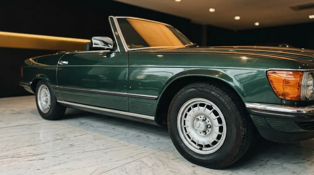 Dunkelgrüner Mercedes-Benz SL Roadster, Chromspiegel und Leichtmetallfelge, auf Marmorboden